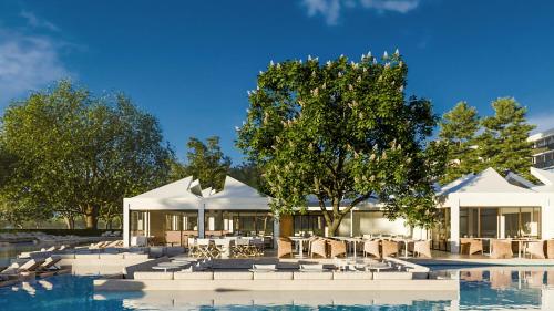 a resort with tables and chairs next to a pool at Resort Cupidon Neptun in Neptun