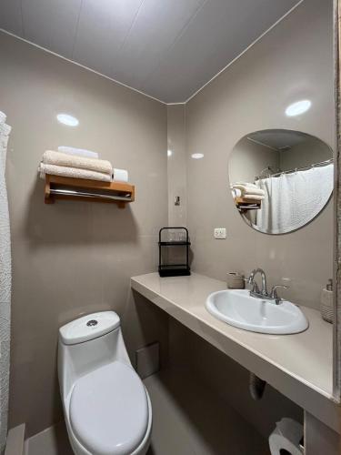 a bathroom with a toilet and a sink and a mirror at Casa Terra Cusco in Cusco