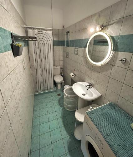a bathroom with two toilets and a sink and a mirror at Pelagos Apartments in Myrtos