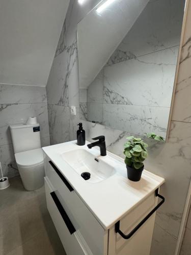 a white bathroom with a sink and a toilet at HAVELI Vinaros in Vinarós