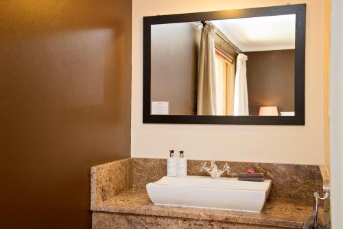 a bathroom with a sink and a mirror at Bayside Guesthouse in Port Elizabeth
