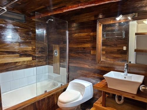 a bathroom with a toilet and a sink and a tub at Hotel Bahía in Marisco Guapinol