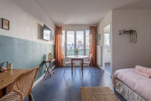 a room with a bed and a table and a window at La Cabane Parking privatif et Balcon in La Riche