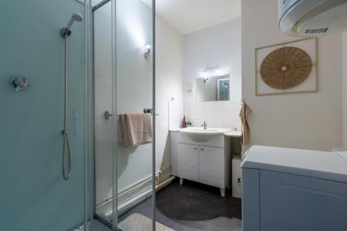 a bathroom with a glass shower and a sink at La Cabane Parking privatif et Balcon in La Riche