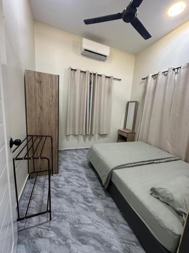 a bedroom with a bed and a ceiling fan at Homestay Khan in Arau