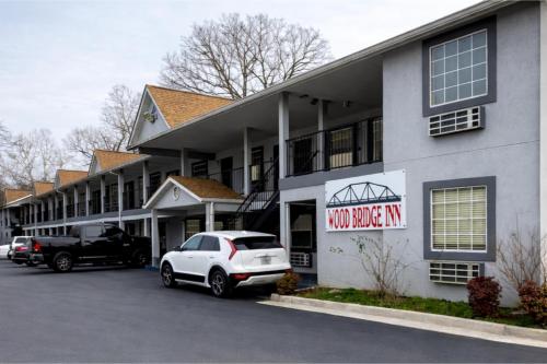 a white car parked in front of a building at Woodbridge Inn By OYO Rome in Rome