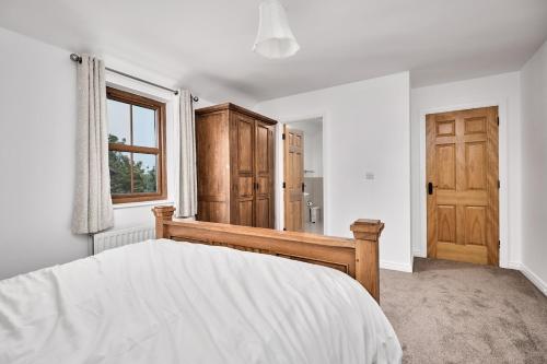 a bedroom with a bed and a wooden door at Cappaghmore by Escape Ordinary in Portstewart