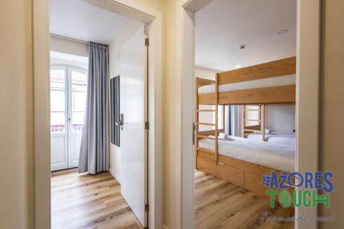 a room with a bunk bed and a doorway at Hostel Casa São Pedro in Angra do Heroísmo