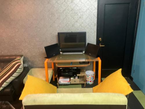 a living room with a table with a laptop on it at 民泊寿屋Kotobukiya Guesthouse in Muroran