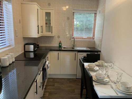 a kitchen with a table with dishes on it at Daisy Cottage in Polegate