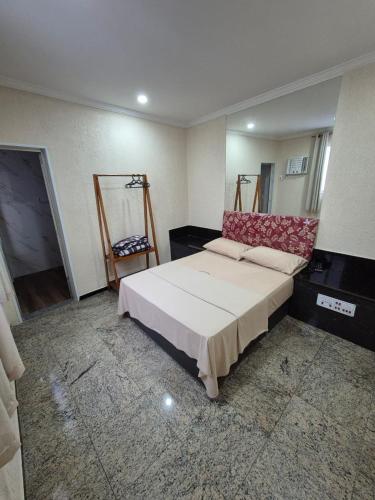 a bedroom with a large bed and a chair at Hotel Casa Blanca - Adults Only in Rio de Janeiro