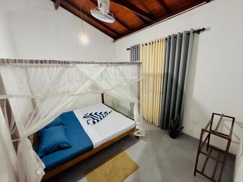 a bedroom with a bed with a mosquito net at Lumora - Midigama in Midigama East