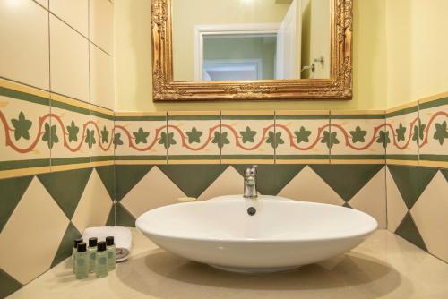 a bathroom with a white sink and a mirror at Sky & Sea View Retreat in Telendos