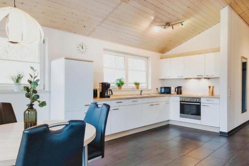 a kitchen with white cabinets and a table and chairs at Haus Stressfrei - Nordhorn in Nordhorn
