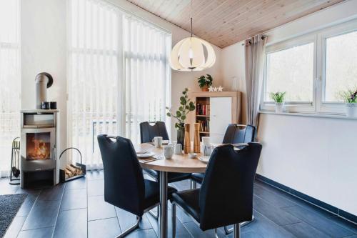 a dining room with a table and chairs and a fireplace at Haus Stressfrei - Nordhorn in Nordhorn