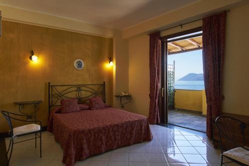 a bedroom with a bed and a large window at Hotel A Pinnata in Lipari