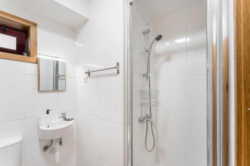 a white bathroom with a shower and a sink at GuestReady - Gaia Gardens Apartments in Vila Nova de Gaia
