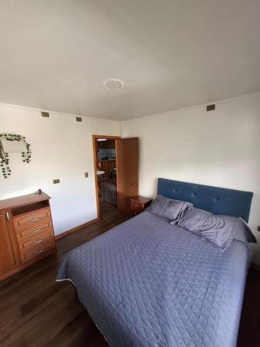 a bedroom with a blue bed and a wooden floor at Habitación privada en Coñaripe de 1 Cama in Coñaripe