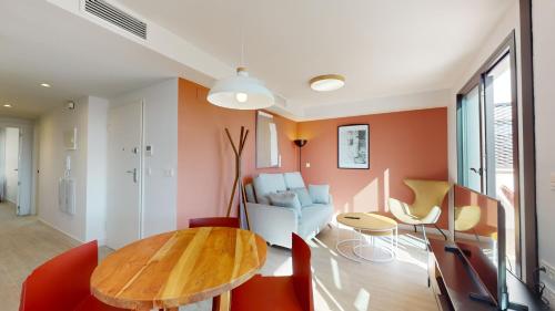 a living room with a wooden table and chairs at Bretón 17- Apartamentos con piscina climatizada en Alicante centro in Alicante