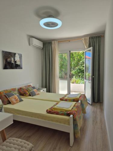 a bedroom with two beds and a large window at Orebic BnB in Orebić