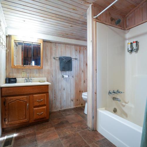 a bathroom with a sink and a tub and a toilet at Settler - by The Chalets in Logan