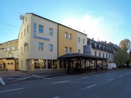 a large yellow building on the side of a street at Hotel Zvonimir in Otočac