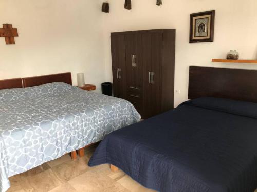 a bedroom with two beds and a cabinet at La casa flores in Atlixco