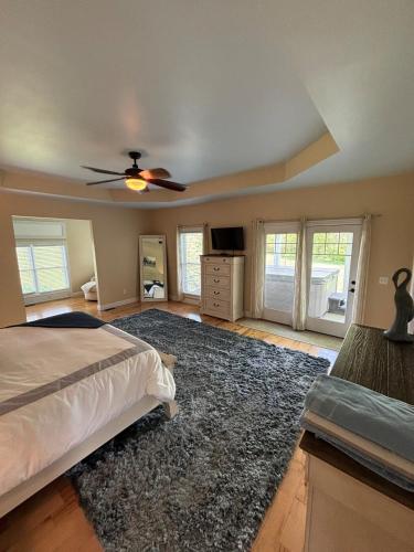 a bedroom with a bed and a ceiling fan at Bourbon Trail Pool & Hot-Tub FUN-ZONE! Game Room! Pool Table! Golden Tee! Ping Pong! Luxurious and Spacious Master Bedroom! Fishing Offsite! in Springfield