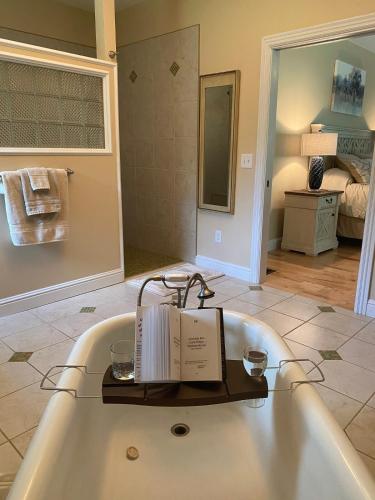 a bath tub with a book and two candles in it at Bourbon Trail Pool & Hot-Tub FUN-ZONE! Game Room! Pool Table! Golden Tee! Ping Pong! Luxurious and Spacious Master Bedroom! Fishing Offsite! in Springfield