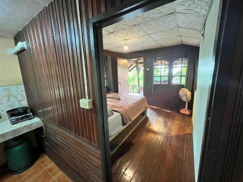 a bedroom with a bed in a wooden wall at Chaloklum Belvedere B6 in Ko Phangan