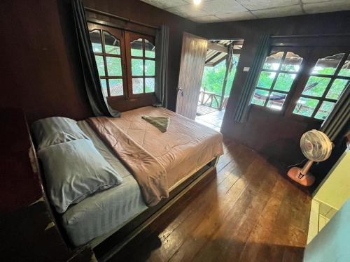 a bedroom with a bed in a room with windows at Chaloklum Belvedere B6 in Ko Phangan