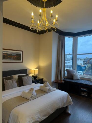 a bedroom with a large bed and a chandelier at Shemara rooms in Keswick