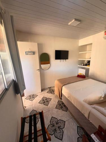 a bedroom with two beds and a tv on the wall at Casa Brisa Noronha in Fernando de Noronha