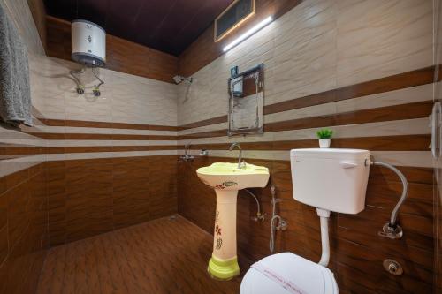 a small bathroom with a toilet and a sink at Hotel Elegant Dreamscape Kasauli by Splendid Retreat Hotels in Kasauli