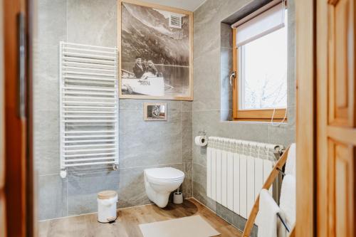 a bathroom with a toilet and a window at Pokoje u Gronicki in Bukowina Tatrzańska