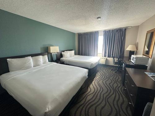 a hotel room with two beds and a window at Baymont Inn & Suites by Wyndham Lincoln NE in Lincoln