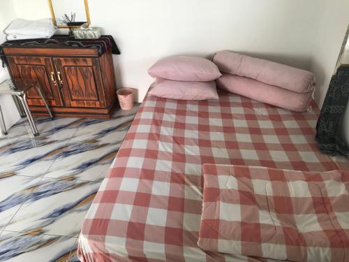 a bedroom with a bed with a checkered blanket at Homestay Jifiqa komodo in Komodo