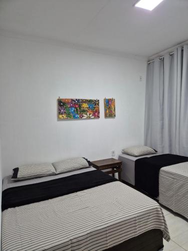 a bedroom with two beds and a painting on the wall at Casa Marzenta in Petrolina