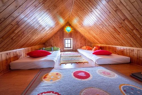 a room with two beds in a wooden attic at Chalupa Svratouch in Svratouch
