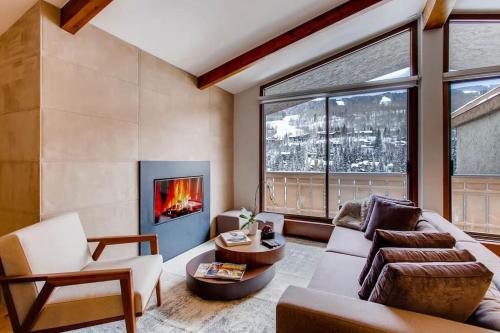 a living room with a couch and a fireplace at Modern Vail Village Mountain View Residence in Vail