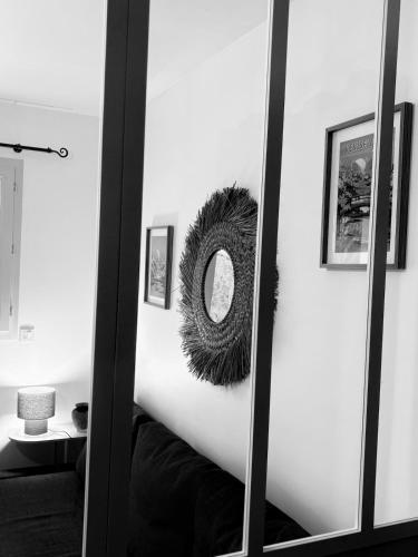 a mirror with a round mirror on a wall at Aux Portes de La Roussille in Niort