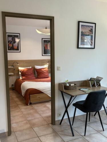 a bedroom with a bed and a table with a chair at Aux Portes de La Roussille in Niort
