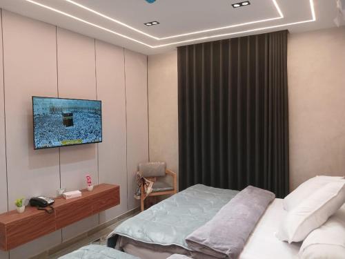 a bedroom with a bed and a tv on the wall at Elmandara Residence in Alexandria