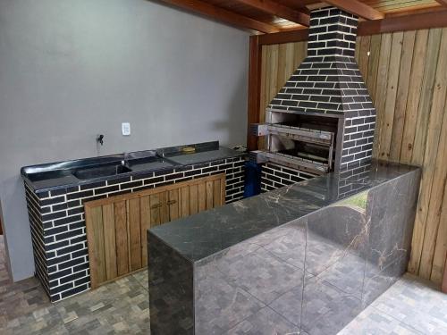 a kitchen with a brick oven in a room at Casa de verão vó judite -praia Sulmar- 4 quartos in Balneário Gaivotas