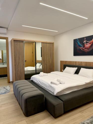 a bedroom with a large bed with a black ottoman at La Villa Kfardebian Stone Villa in Fārayyā