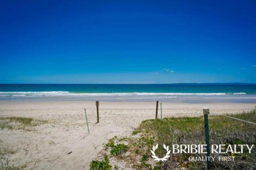 a sandy beach with the ocean in the background at Eden Cottage in Woorim