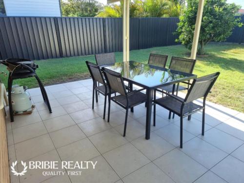 a glass table and chairs on a patio at Eden Cottage in Woorim