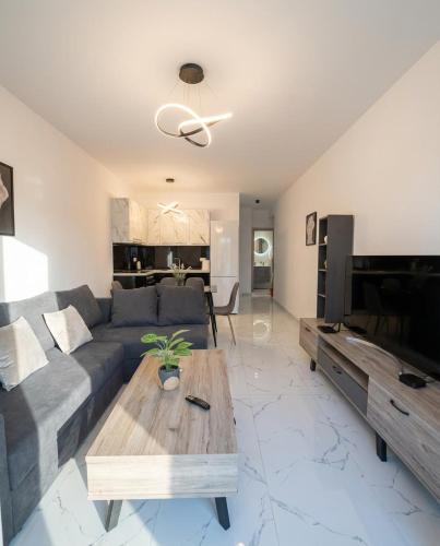 a living room with a couch and a table at White Port Suite in Ágios Rókkos