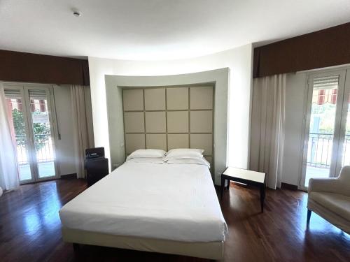 a bedroom with a large white bed and a couch at Best Western Cesena Hotel in Cesena
