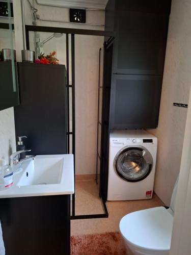a bathroom with a washing machine and a sink at Charmig stuga med havsutsikt in Karlskrona